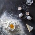 Dough on black table with flour and ingredients Royalty Free Stock Photo