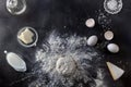 Dough on black table with flour and ingredients Royalty Free Stock Photo