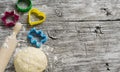 Dough, cookie cutters, rolling pin on a light wooden background Royalty Free Stock Photo