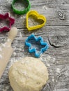 Dough, cookie cutters, rolling pin on a light wooden background Royalty Free Stock Photo