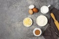 Dough ingredients, milk, eggs, flour and whisk, butter, brown cane sugar, on a gray table, top view, background, no Royalty Free Stock Photo