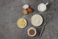 Dough ingredients, milk, eggs, flour and whisk, butter, brown cane sugar, on a gray table, top view, background, no Royalty Free Stock Photo