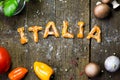 Dough letters and vegetables on rustic wooden table with flour,