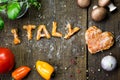 Dough letters and vegetables on rustic wooden table, word italy