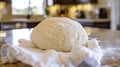 The dough now risen to twice its original size sits under a clean white kitchen towel with a few bubbles dotting its