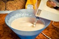 Dough for pancakes, whipped with a mixer in a blue salad bowl. concept of home food. Royalty Free Stock Photo