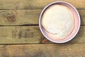 Dough in a pink bowl on rustic rough wooden table