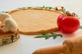 Dough for pizza basis ready for cooking and natural ingredients for vegetarian pizza on the white background with a rolling pin Royalty Free Stock Photo