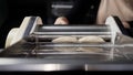 Putting the dough into the dough sheeter. The chef processes the dough in the machine in the kitchen. Rolling out dough Royalty Free Stock Photo