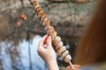 Dough on a stick cooked on a fire in the forest in the hands of a girl