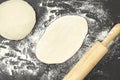 Dough and wood rolling pin on clean black background top view