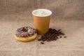 Doughnut, coffee beans and coffee on flax background