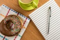 Doughnut coffee and notepad with pen