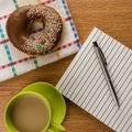 Doughnut coffee and notepad with pen