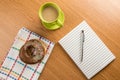 Doughnut coffee and notepad with pen