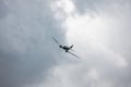 Douglas DC-3 transport plane flying in grey clouds