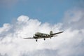 Douglas DC-3 transport plane flying with landing gear out