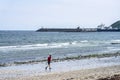 Douglas, Isle of Man. Man running at the beach with cruise ship close to shore. Powerful runner training outdoor on summer Royalty Free Stock Photo