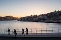 Douro River view, silhouette of tourists and Ribeira district skyline at dusk, Porto, Portugal