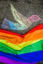 Dove of peace painted with chalk on the street, under it the rainbow flag