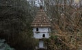 A dovecote shelter for birds and doves pigeons with multiple entrances and a pointed roof on a wooden post Royalty Free Stock Photo