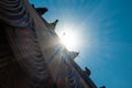 Doves sitting on the roof against the background of blue sky and sunbeams. Rainbow optical effect from the sun.