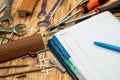 dowel screws and keys are scattered on the table next to a folder and a pen. Royalty Free Stock Photo