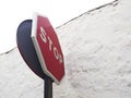 Down angle view of stop sign against white rough concrete wall. Side view of a Stop road sign. Regulatory signs, Stop traffic sign Royalty Free Stock Photo