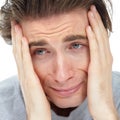 Down and out. Sad young man holding his face while looking away - closeup. Royalty Free Stock Photo