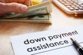 Down payment assistance form and dollar banknotes.