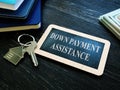 Down payment assistance phrase and house key. Royalty Free Stock Photo