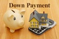 Down Payment message with mortgage calculator with a house on a calculator and piggy bank