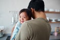 Down syndrome, baby and father bonding in a kitchen, happy and relax in their home together. Disability, development and