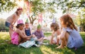 Down syndrome child with friends on birthday party outdoors in garden.