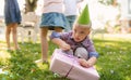 Down syndrome child with friends on birthday party outdoors in garden.