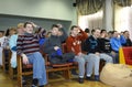 Down syndrome children sitting in chairs during meeting at the conference hall of a boarding school