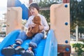 Down syndrome kid playing with teddy bear on slide at park Royalty Free Stock Photo