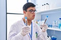 Down syndrome man wearing scientist uniform holding test tubes at laboratory Royalty Free Stock Photo