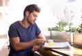 Down time in the cafe. A young man enjoying a cup of coffee in a coffee shop. Royalty Free Stock Photo