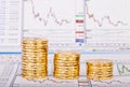 Down trend stacks of golden coins and financial chart as the background. Selective focus Royalty Free Stock Photo
