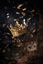 downfall of a kingdom concept. falling shattering shattered and cracked golden royalty crown. fantasy medieval.