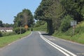Downhill on an empty road in Somerset, England. Lush green rolling hills of the Quantocks can be seen in the background Royalty Free Stock Photo