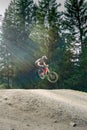 Downhill mountain biker jumping high and riding hard in Lenzerheide in the Swiss Alps