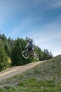 Downhill mountain biker jumping high and riding hard in Lenzerheide in the Swiss Alps