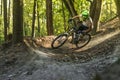 Downhill mountain biker in motion crossing trails.