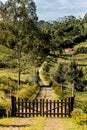 Downhill rocky pathway leading to wooden gate, forest in backgro Royalty Free Stock Photo