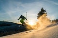 Downill skier jumping over natural kicker in powder snow and sunset conditions Royalty Free Stock Photo