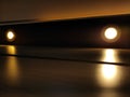 Downlights glow in the room and reflected in the glossy wall Royalty Free Stock Photo