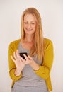 Downloading a new app is so easy. a happy woman sending a text message on her mobile phone. Royalty Free Stock Photo