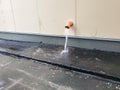 Downpipe on the facade of a modern building. heavy rain, water flows out of the downspout onto the sidewalk.